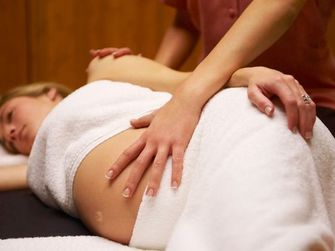 Pregnant woman receiving gentle hands-on therapy on her hip